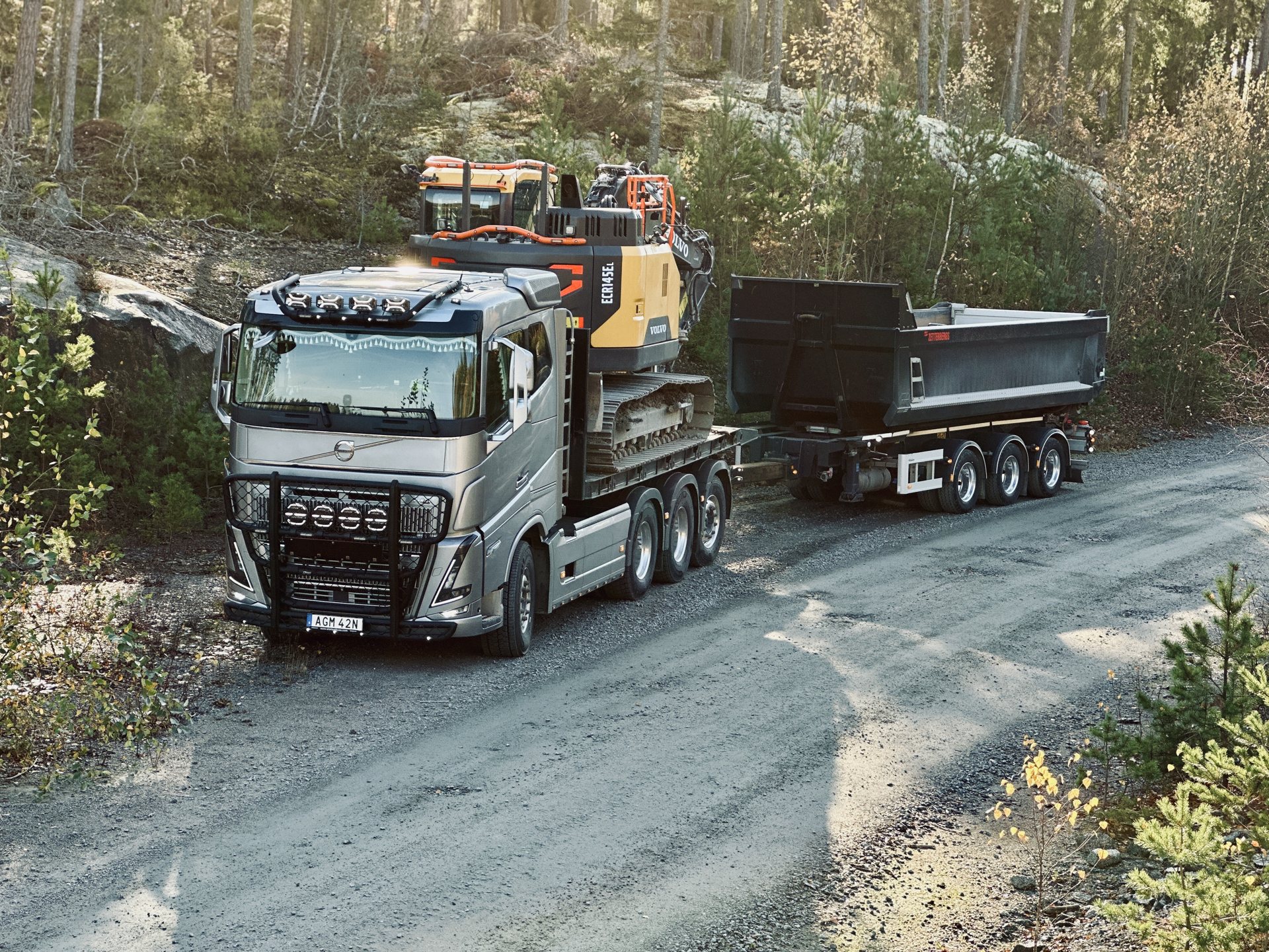 Maskintransport – Volvo-lastbil med grävmaskin på skogsväg