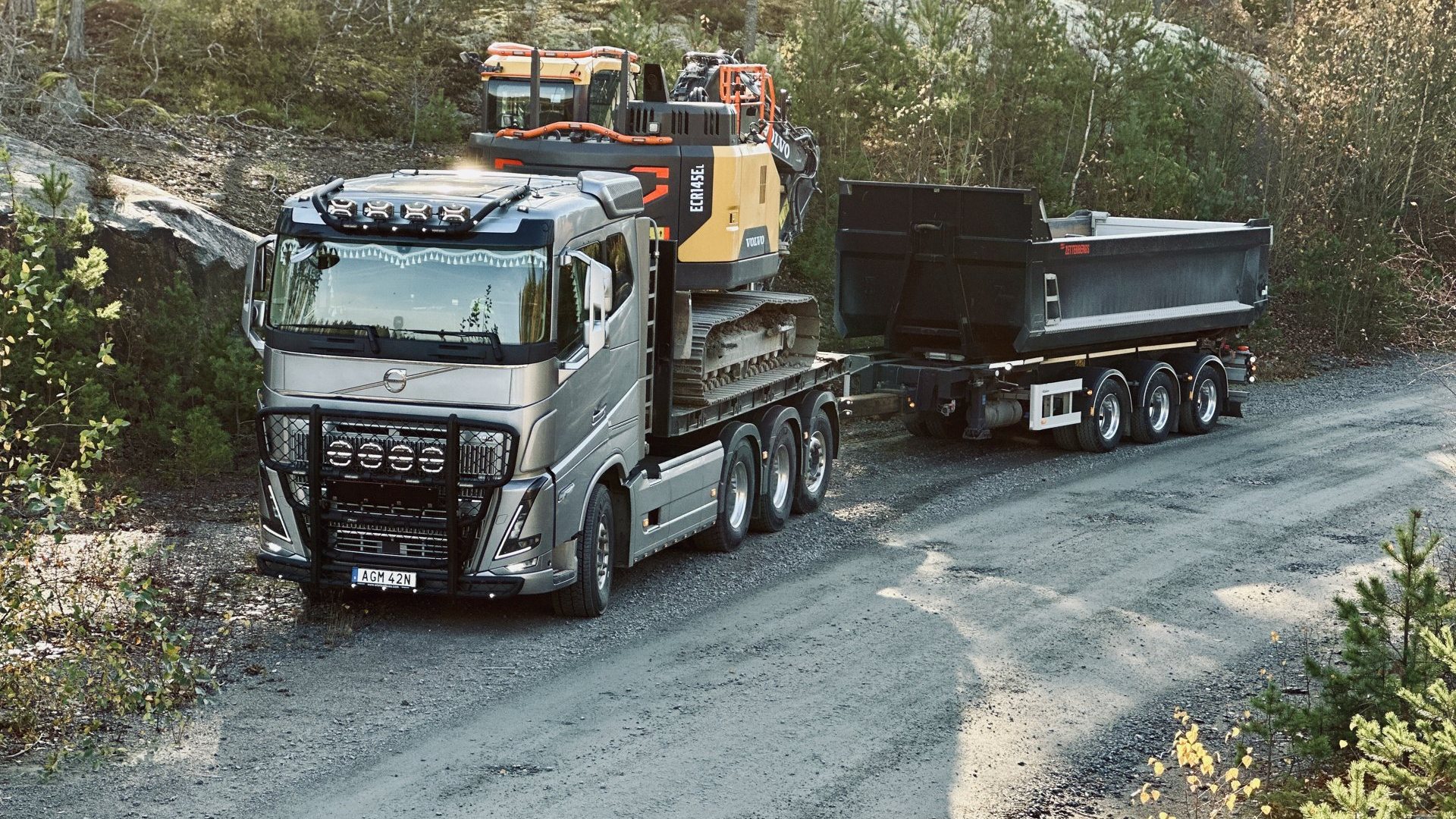 Askarbäck Volvo-lastbil med grävmaskin på väg till uppdrag i Mälardalen
